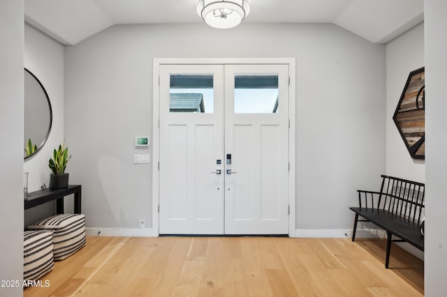 foyer entrance with vaulted ceiling and light hardwood / wood-style floors