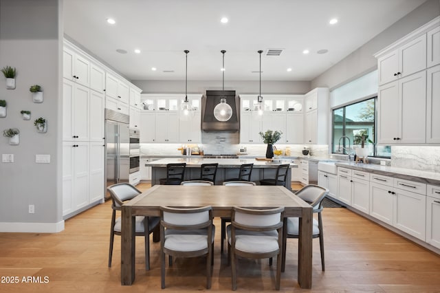 dining area with sink and light hardwood / wood-style flooring