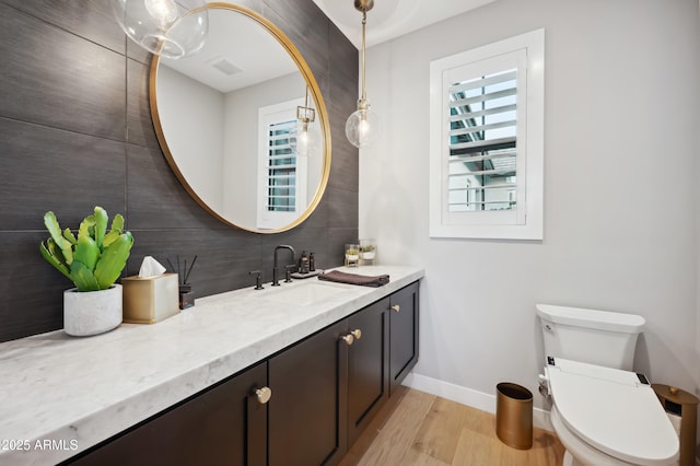 bathroom featuring vanity, hardwood / wood-style floors, and toilet