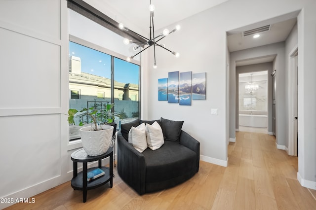 sitting room featuring a notable chandelier and light hardwood / wood-style floors