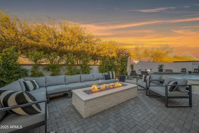 patio terrace at dusk featuring an outdoor living space with a fire pit