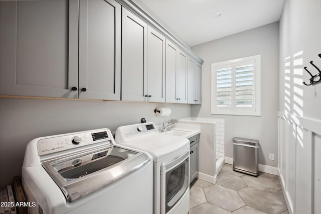 laundry room with sink, light tile patterned floors, washer and clothes dryer, and cabinets