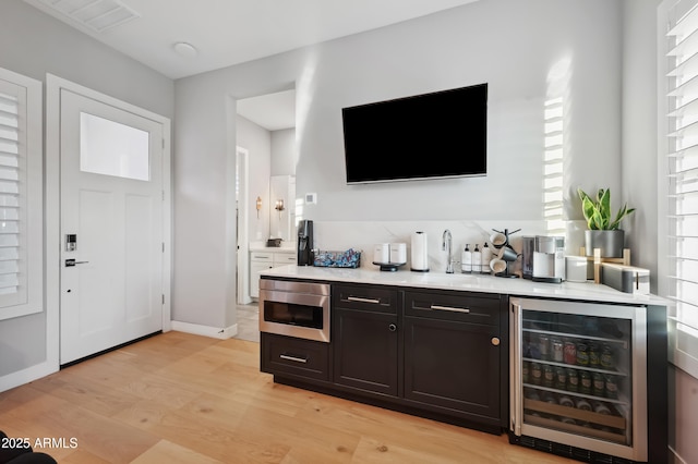 bar with wine cooler, sink, and light hardwood / wood-style floors