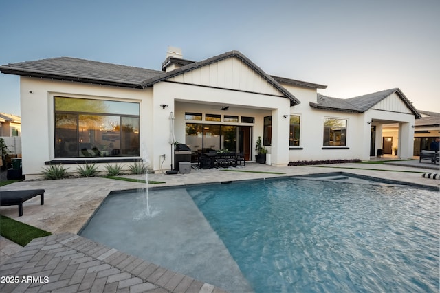 rear view of house featuring pool water feature, ceiling fan, and a patio area