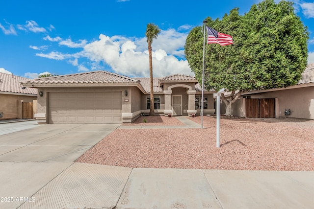 mediterranean / spanish-style home featuring stucco siding, concrete driveway, an attached garage, and a tile roof