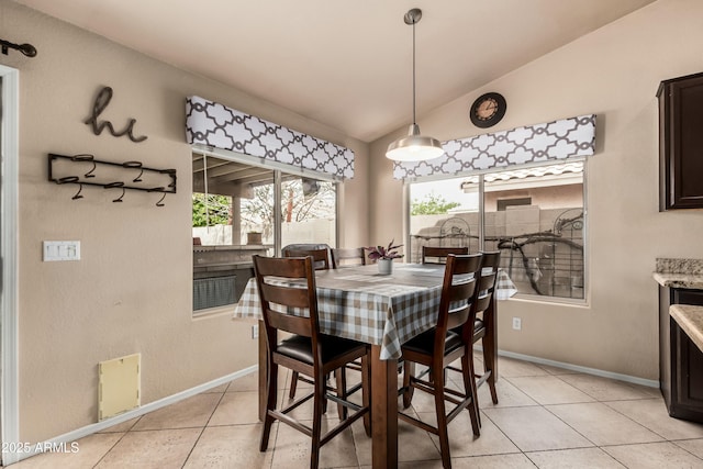 dining space with light tile patterned flooring, baseboards, and lofted ceiling