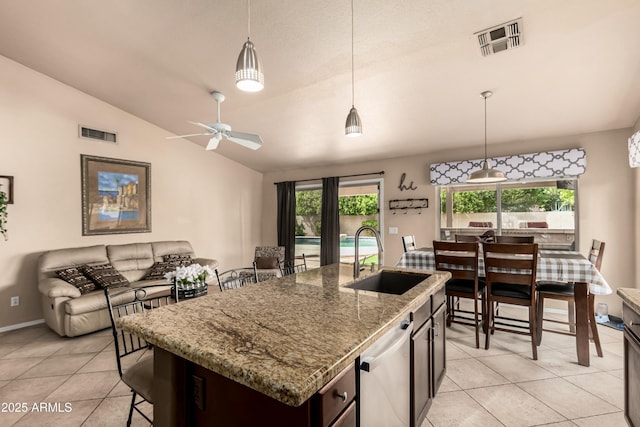 kitchen featuring hanging light fixtures, visible vents, lofted ceiling, and a sink