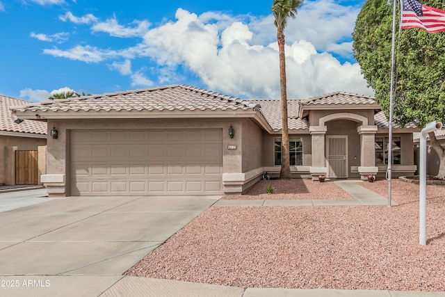 mediterranean / spanish home with a tile roof, an attached garage, driveway, and stucco siding