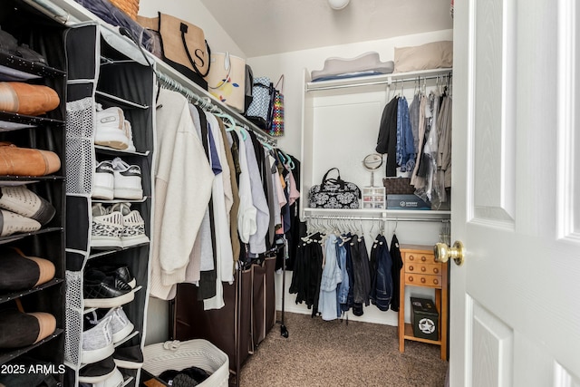 walk in closet featuring carpet floors and lofted ceiling