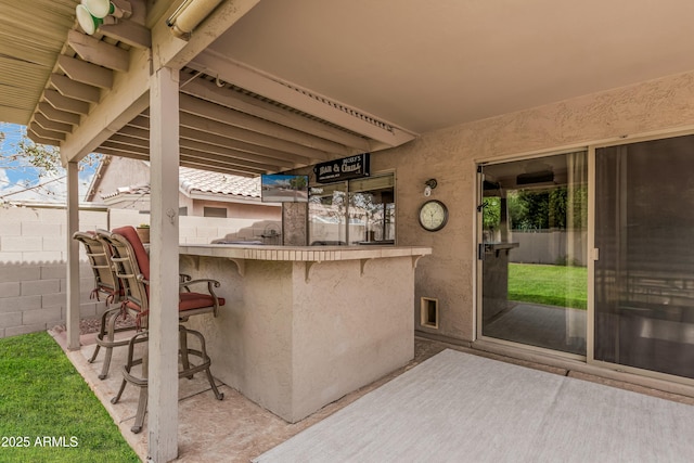 view of patio featuring fence and outdoor dry bar