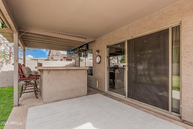 view of patio / terrace with outdoor dry bar and fence