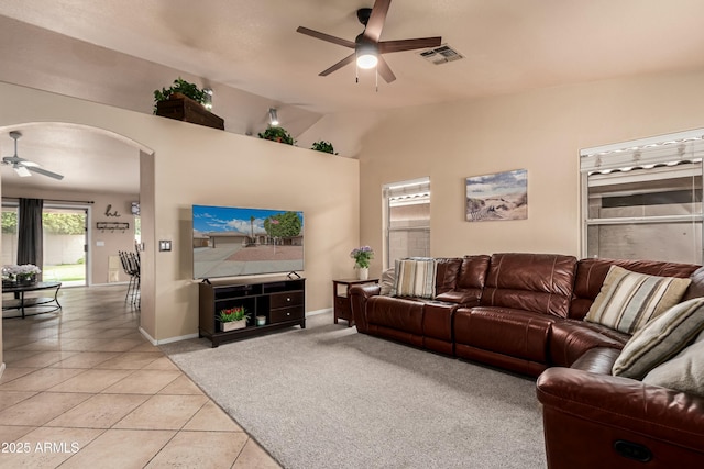 living room featuring visible vents, ceiling fan, vaulted ceiling, arched walkways, and light tile patterned flooring