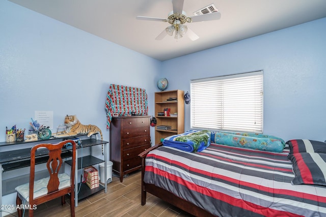 bedroom with visible vents, wood finish floors, and a ceiling fan