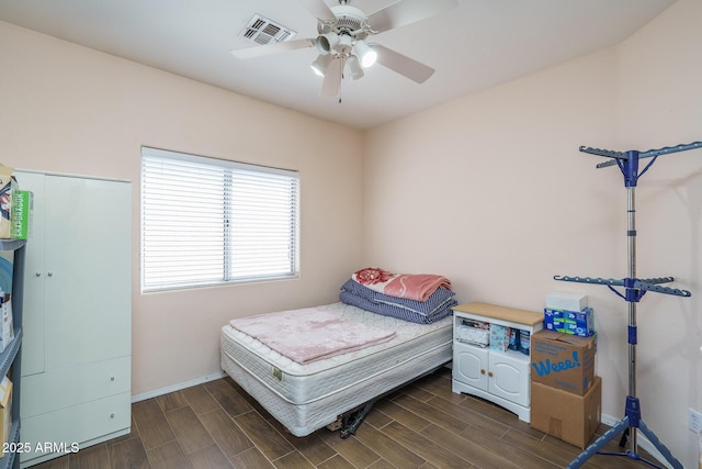 bedroom with a ceiling fan, wood tiled floor, baseboards, and visible vents