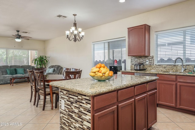 kitchen featuring ceiling fan with notable chandelier, open floor plan, a sink, and light tile patterned floors