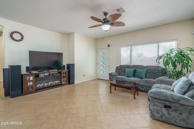 tiled living area featuring arched walkways, ceiling fan, and visible vents