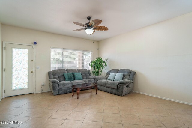 living area with light tile patterned flooring, baseboards, and ceiling fan