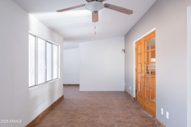 spare room with baseboards and a ceiling fan