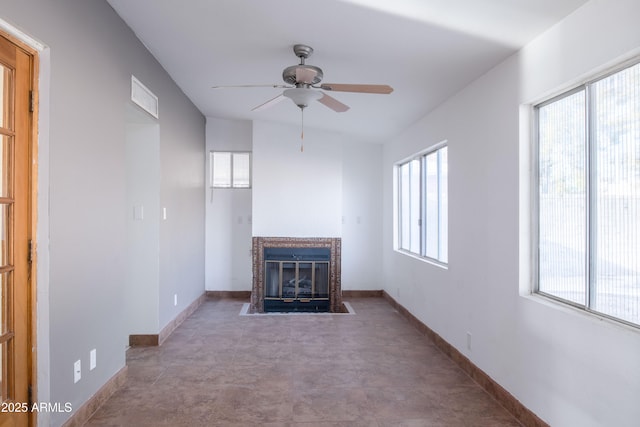 unfurnished living room with a fireplace with flush hearth, baseboards, visible vents, and ceiling fan