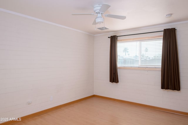 empty room with light wood finished floors, visible vents, crown molding, ceiling fan, and baseboards