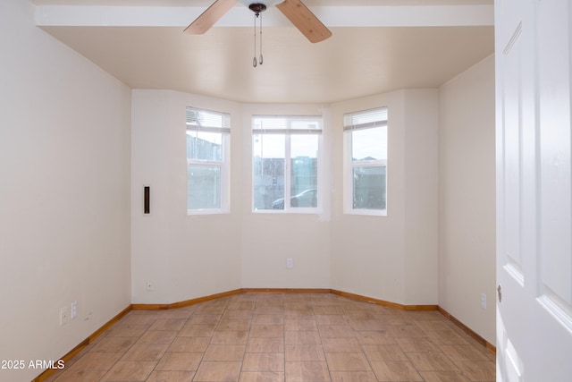 unfurnished room featuring a ceiling fan and baseboards