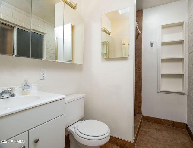 full bath featuring toilet, tiled shower, tile patterned flooring, baseboards, and vanity