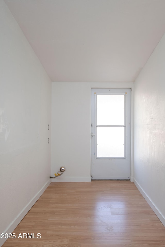 unfurnished room with light wood-type flooring and baseboards