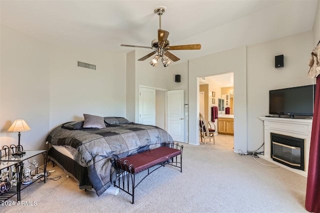 bedroom featuring ensuite bath, ceiling fan, and carpet flooring