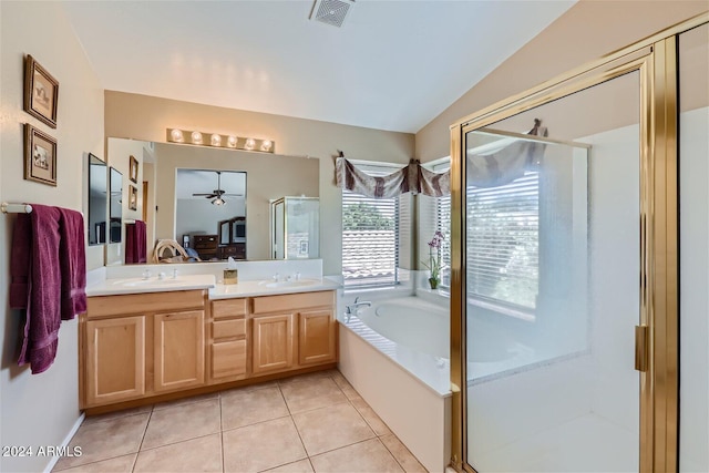 bathroom featuring oversized vanity, vaulted ceiling, tile flooring, plus walk in shower, and dual sinks