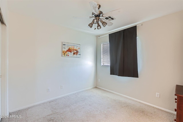 carpeted spare room with ceiling fan