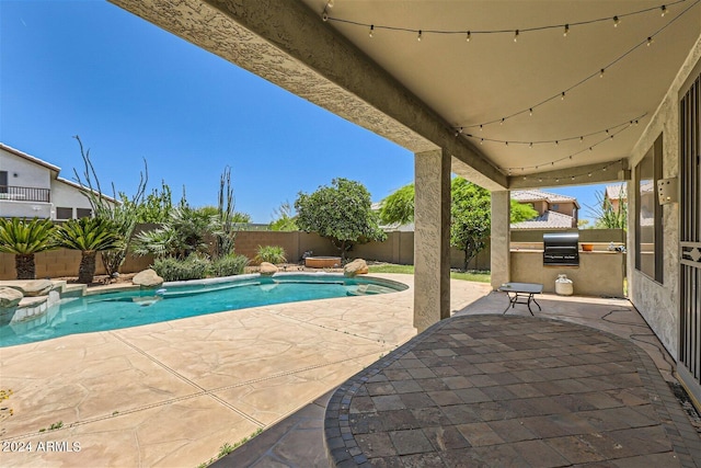 view of swimming pool with an outdoor kitchen and a patio area