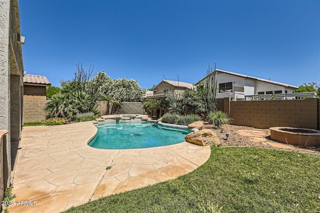 view of pool featuring a lawn, an in ground hot tub, and a patio area