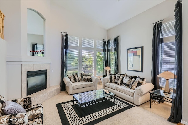 carpeted living room with a towering ceiling and a tiled fireplace