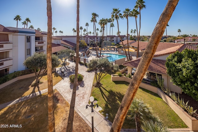 surrounding community featuring a swimming pool, a lawn, and a patio