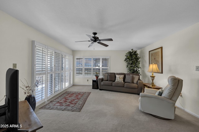 carpeted living room with ceiling fan