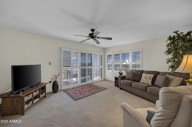living room with ceiling fan, plenty of natural light, and light carpet