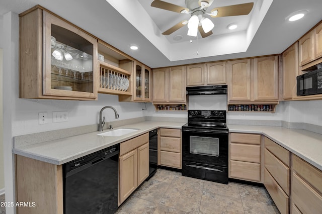 kitchen featuring black appliances, a raised ceiling, and light brown cabinets