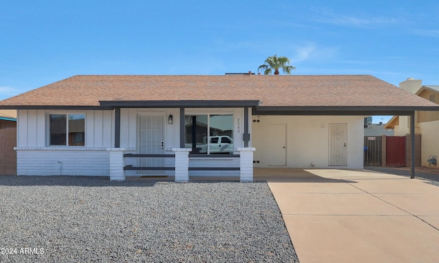 ranch-style house featuring a carport and covered porch