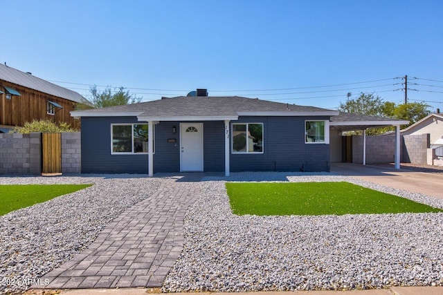 single story home with a shingled roof, an attached carport, fence, and driveway