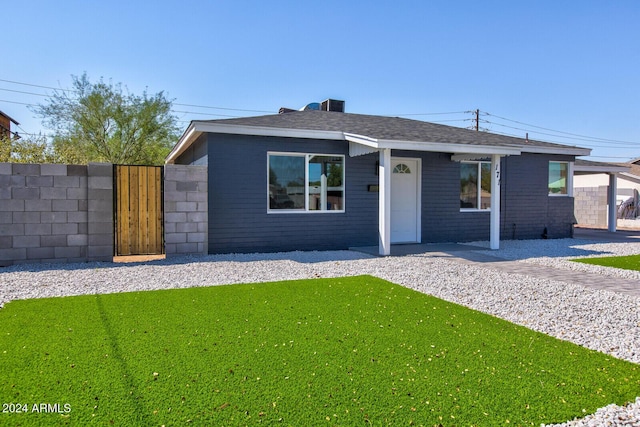 view of front of house featuring a shingled roof, a front yard, fence, and a gate