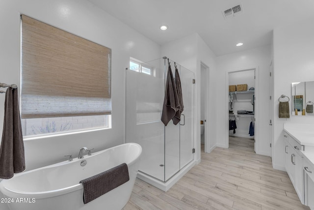 bathroom with vanity, independent shower and bath, and hardwood / wood-style flooring