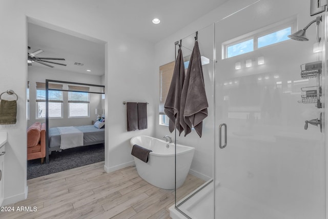 bathroom with vanity, ceiling fan, plus walk in shower, and hardwood / wood-style flooring