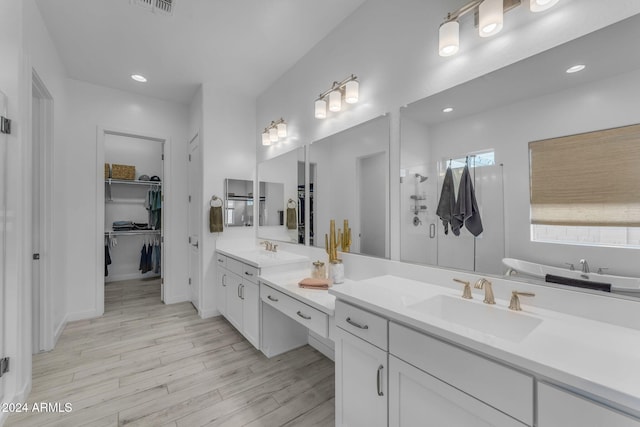 bathroom with hardwood / wood-style floors, vanity, and a washtub