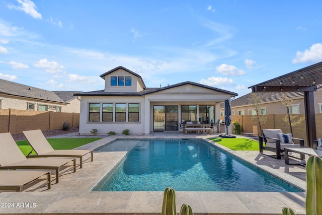 back of house with a fenced in pool and a patio area