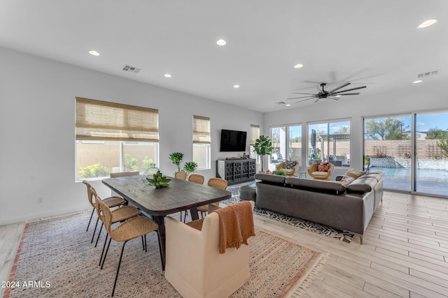 dining space with ceiling fan and light hardwood / wood-style flooring