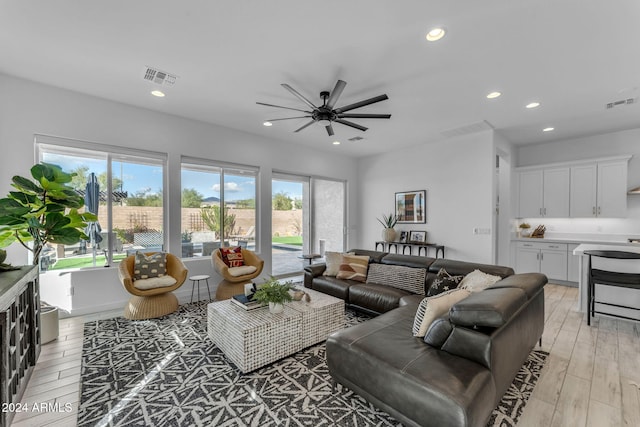 living room with ceiling fan and light wood-type flooring