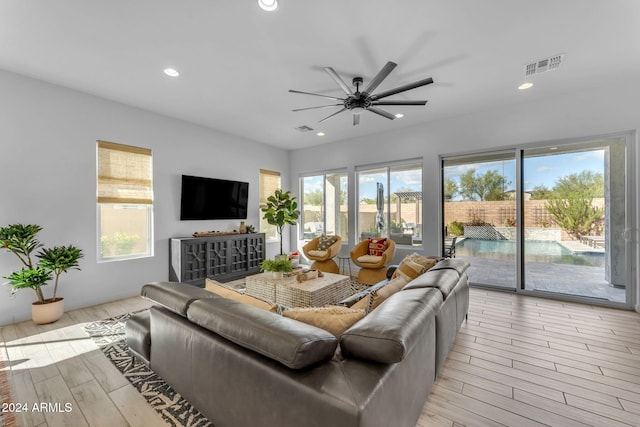 living room featuring ceiling fan and light wood-type flooring