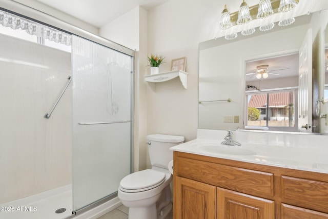 full bathroom featuring vanity, a shower stall, toilet, and a ceiling fan