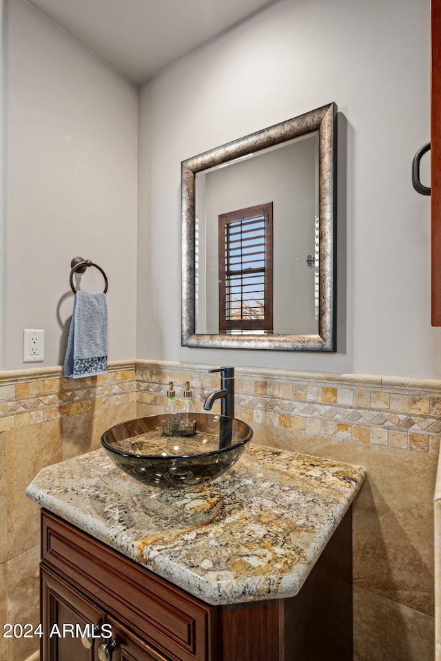 bathroom featuring vanity, tile walls, and a wainscoted wall