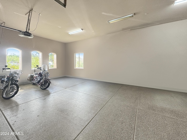 garage with a garage door opener and baseboards